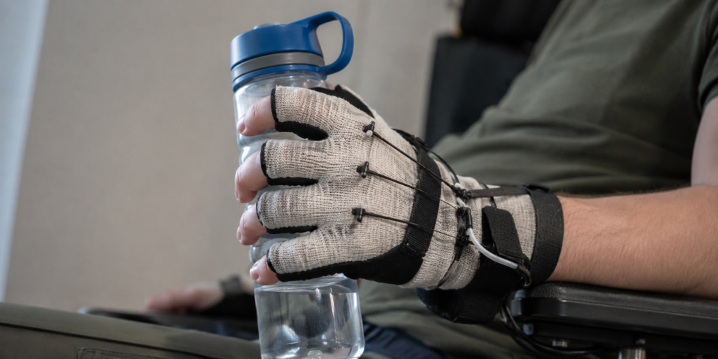 Textile soft hand exoskeleton assisting a user to grasp an everyday object