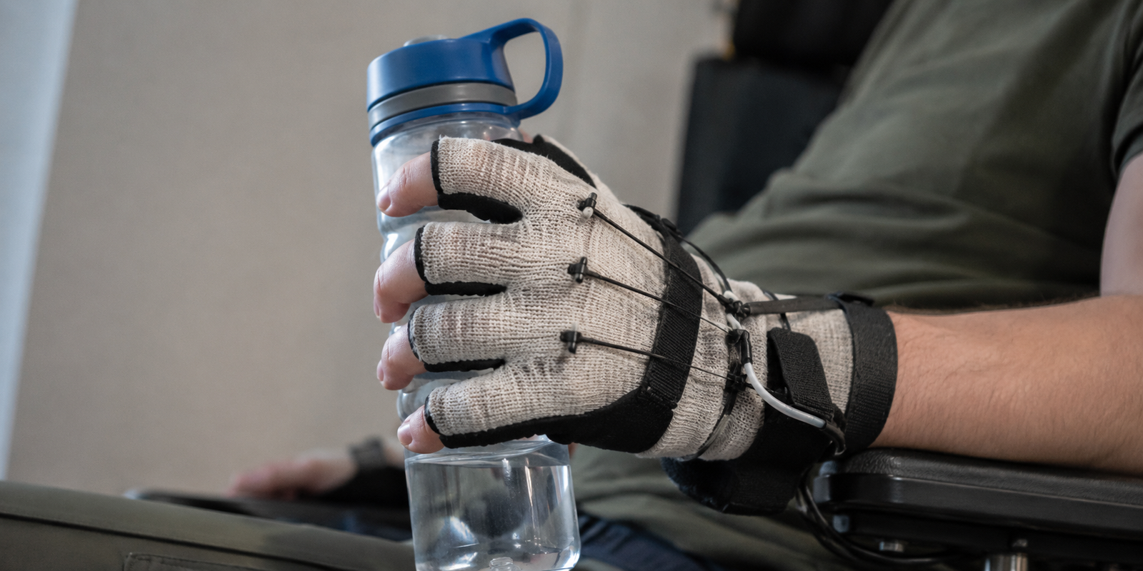 Textile soft hand exoskeleton assisting a user to grasp an everyday object