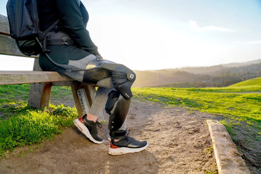 Person wearing the Roam Robotics Ascend smart knee orthosis while seated outdoors