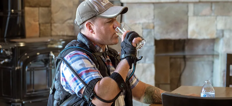 Veteran using a powered grip-assistance glove during an everyday task