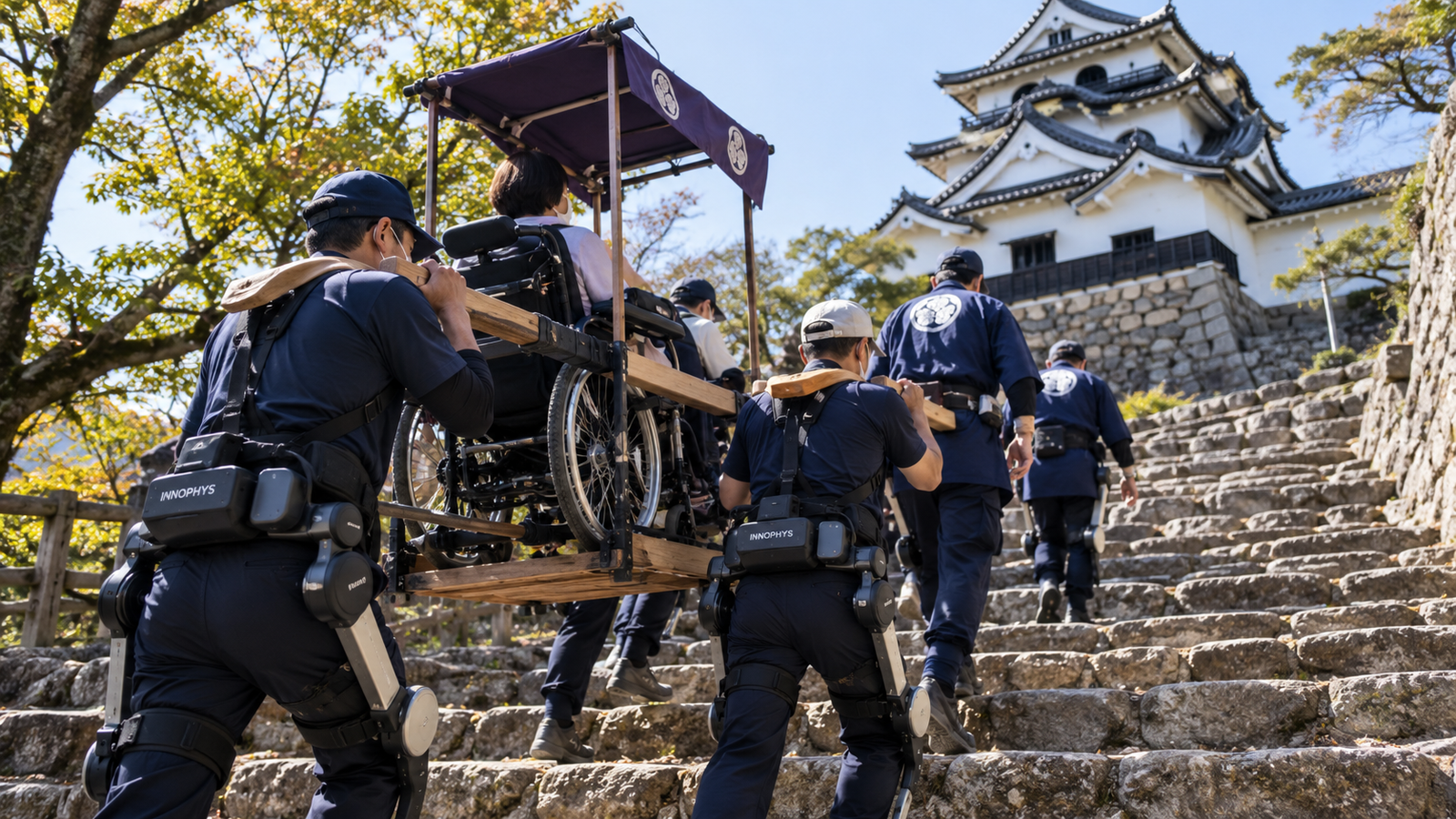 Workers wearing back-support assist suits carry a wheelchair user up stone steps at a Japanese castle.